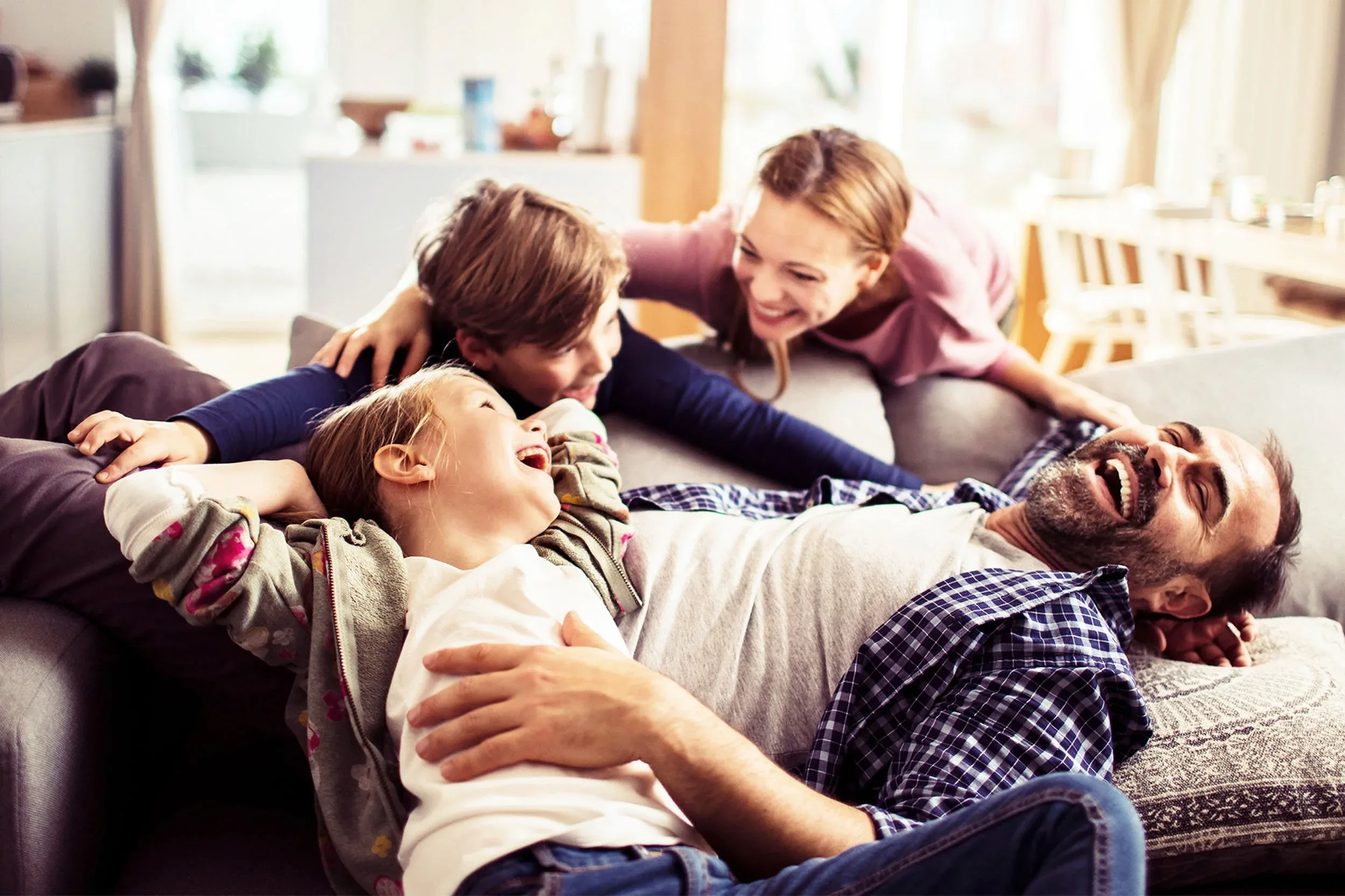 Family of four laughing together in their newly remodeled living room