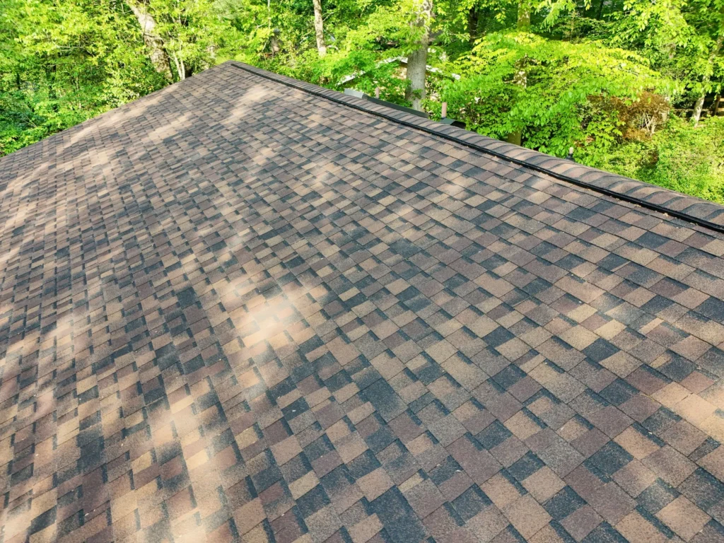 Expert roof installers are laying down CertainTeed Roofing Underlayment on the roof of a townhouse.