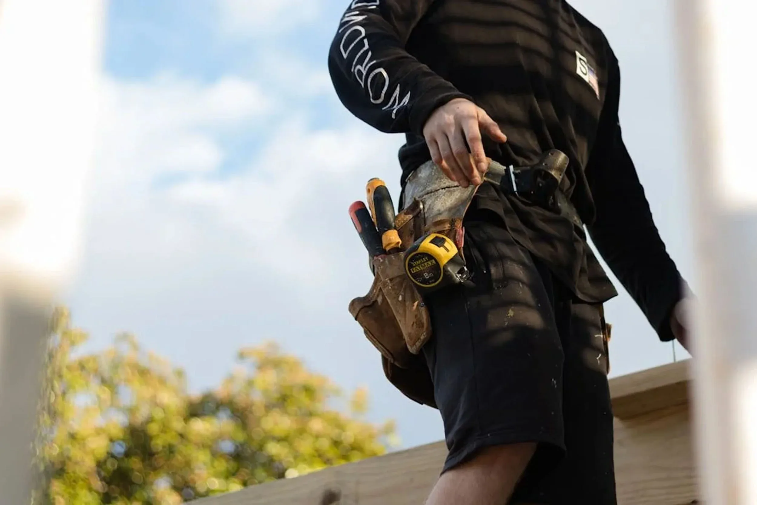 Four Seasons roofer with tool belt on DMV home
